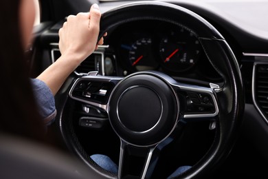 Photo of Woman holding steering wheel while driving her car, closeup