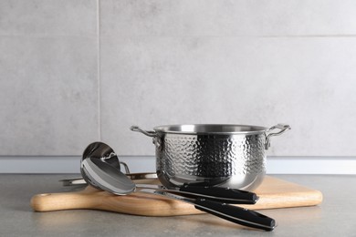 Set of different cooking utensils on grey countertop in kitchen