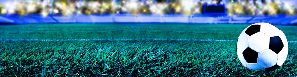 Soccer ball on green football field grass, space for text. Banner design