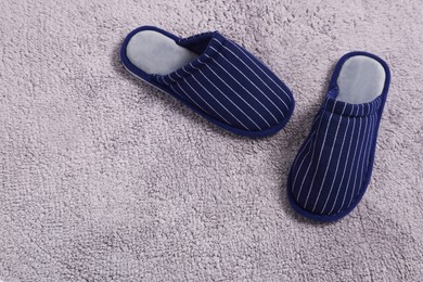 Pair of stylish slippers on light grey carpet, top view. Space for text