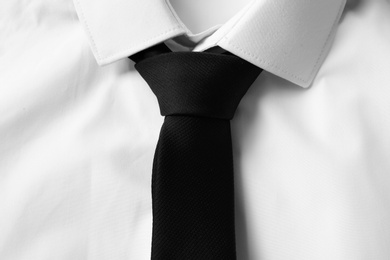 Black male necktie on white shirt, closeup