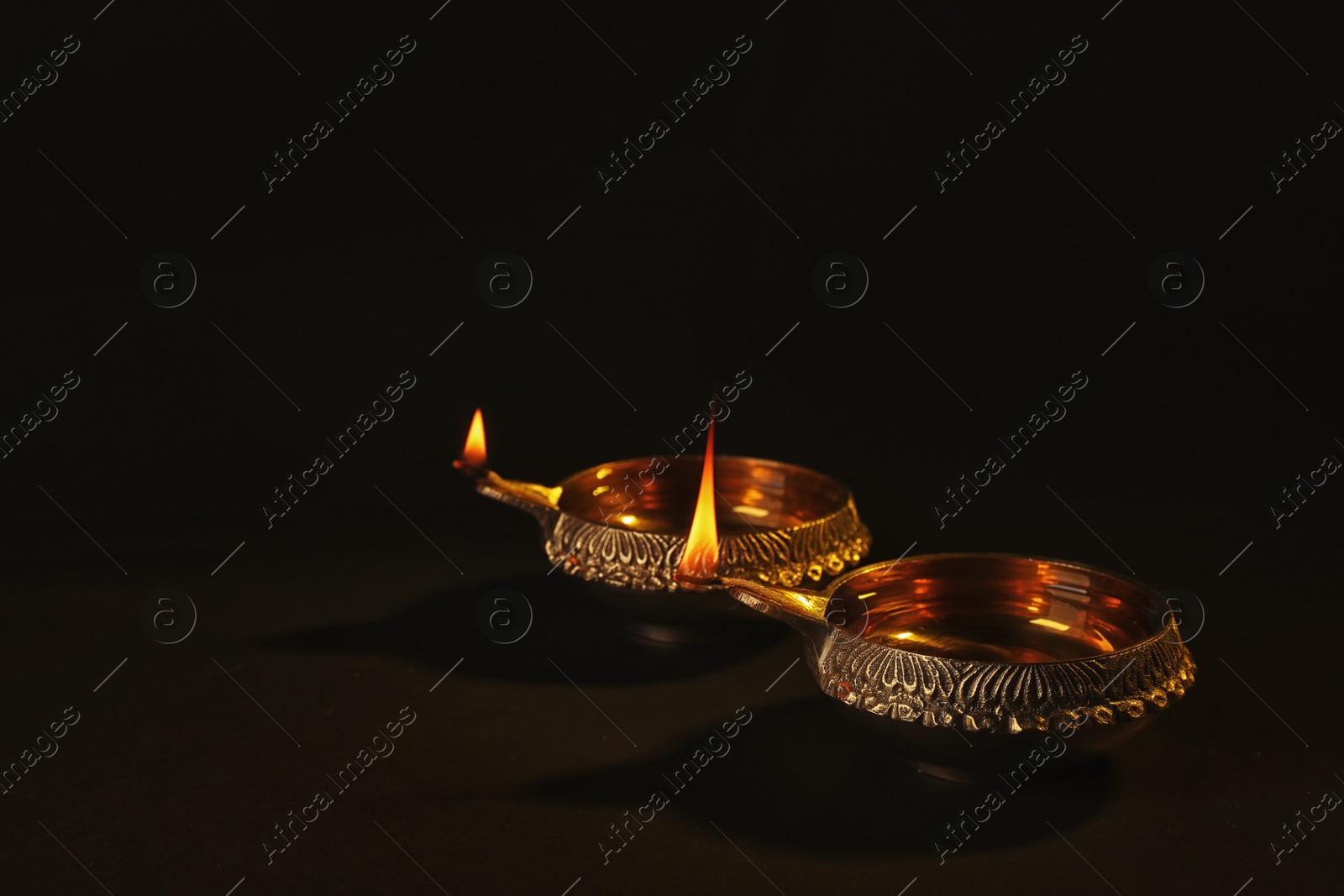 Photo of Diwali diyas or clay lamps on dark background