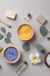 Flat lay composition with spa products and eucalyptus branches on grey background