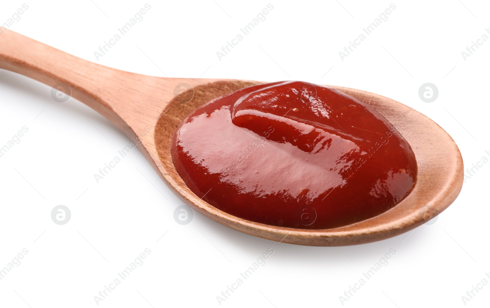 Photo of Tasty ketchup in wooden spoon isolated on white, closeup