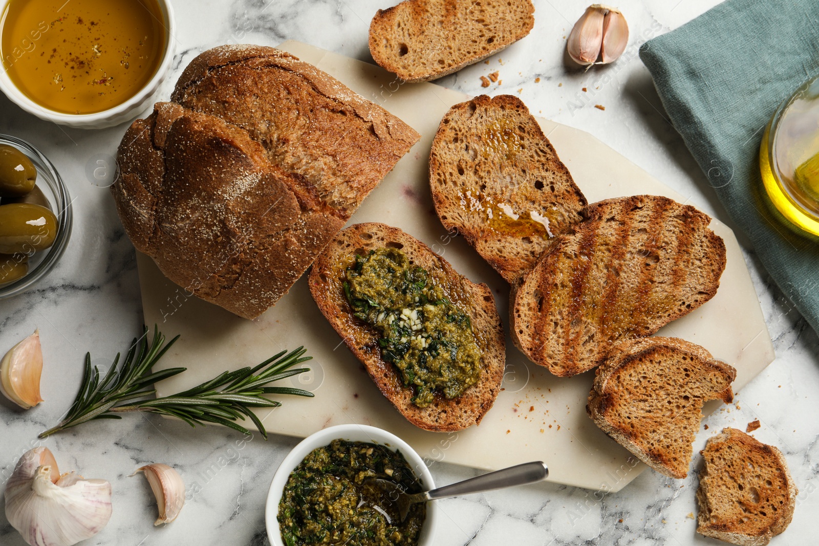 Photo of Tasty bruschettas with pesto on white marble table, flat lay