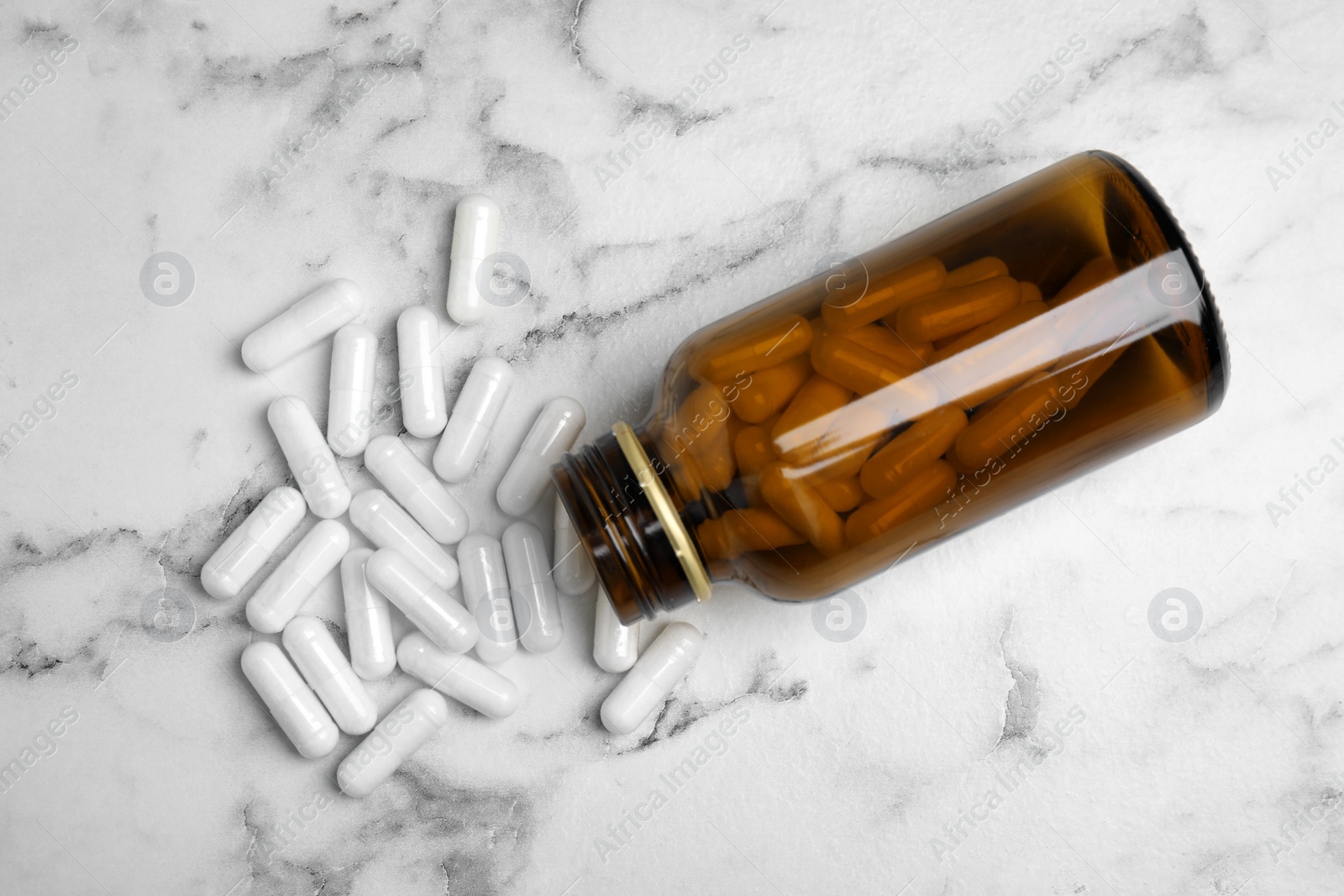 Photo of Amino acid pills on white marble table, flat lay