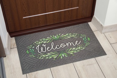 Photo of Beautiful doormat with word Welcome on floor near entrance