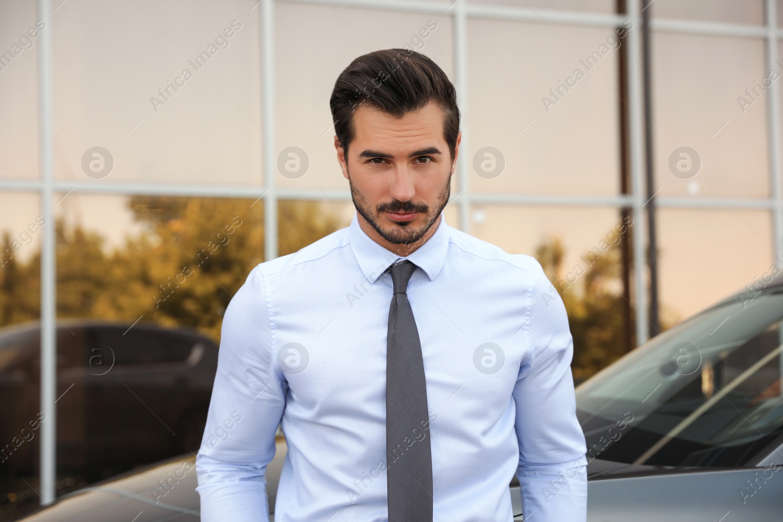 Photo of Attractive young man near luxury car outdoors