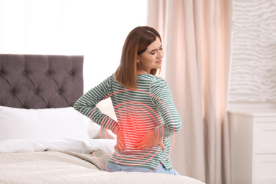 Image of Woman suffering from back pain after sleeping on uncomfortable mattress at home