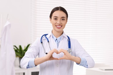 Doctor showing heart gesture with hands in clinic