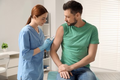 Photo of Doctor giving hepatitis vaccine to patient in clinic