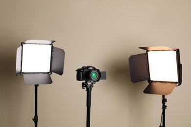 Professional video camera and lighting equipment on beige background