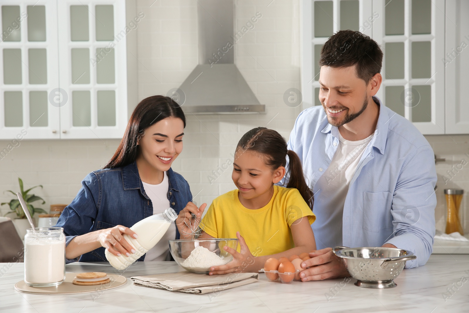 Photo of Happy family cooking together at table in kitchen. Adoption concept