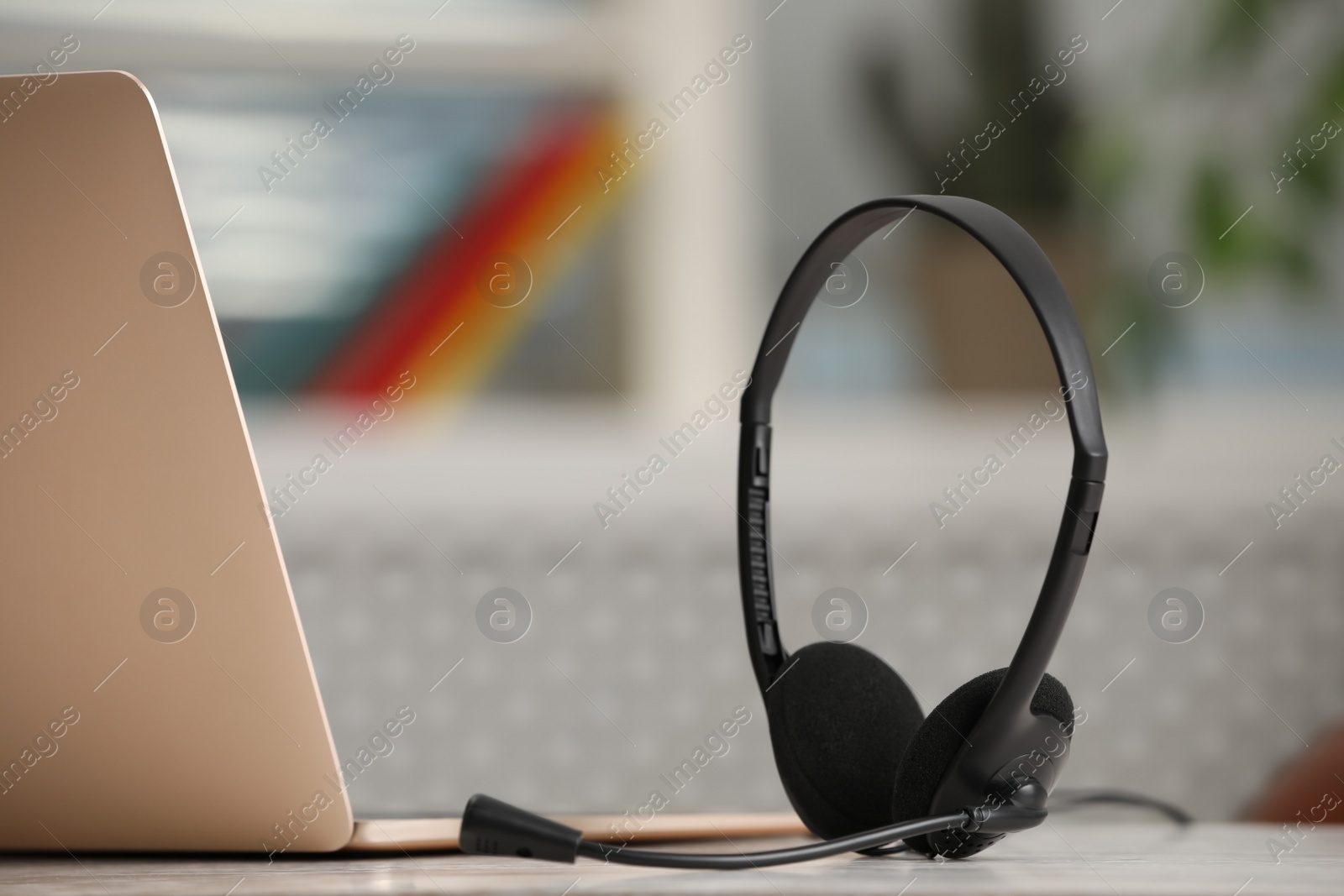 Photo of Headset and laptop on table indoors. Hotline concept