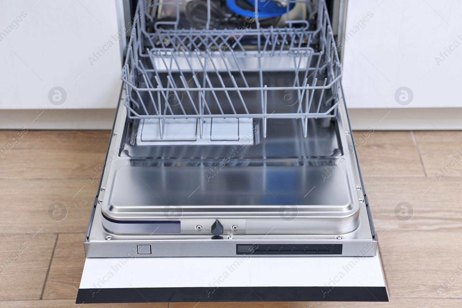 Photo of Open clean empty dishwasher in kitchen. Home appliance