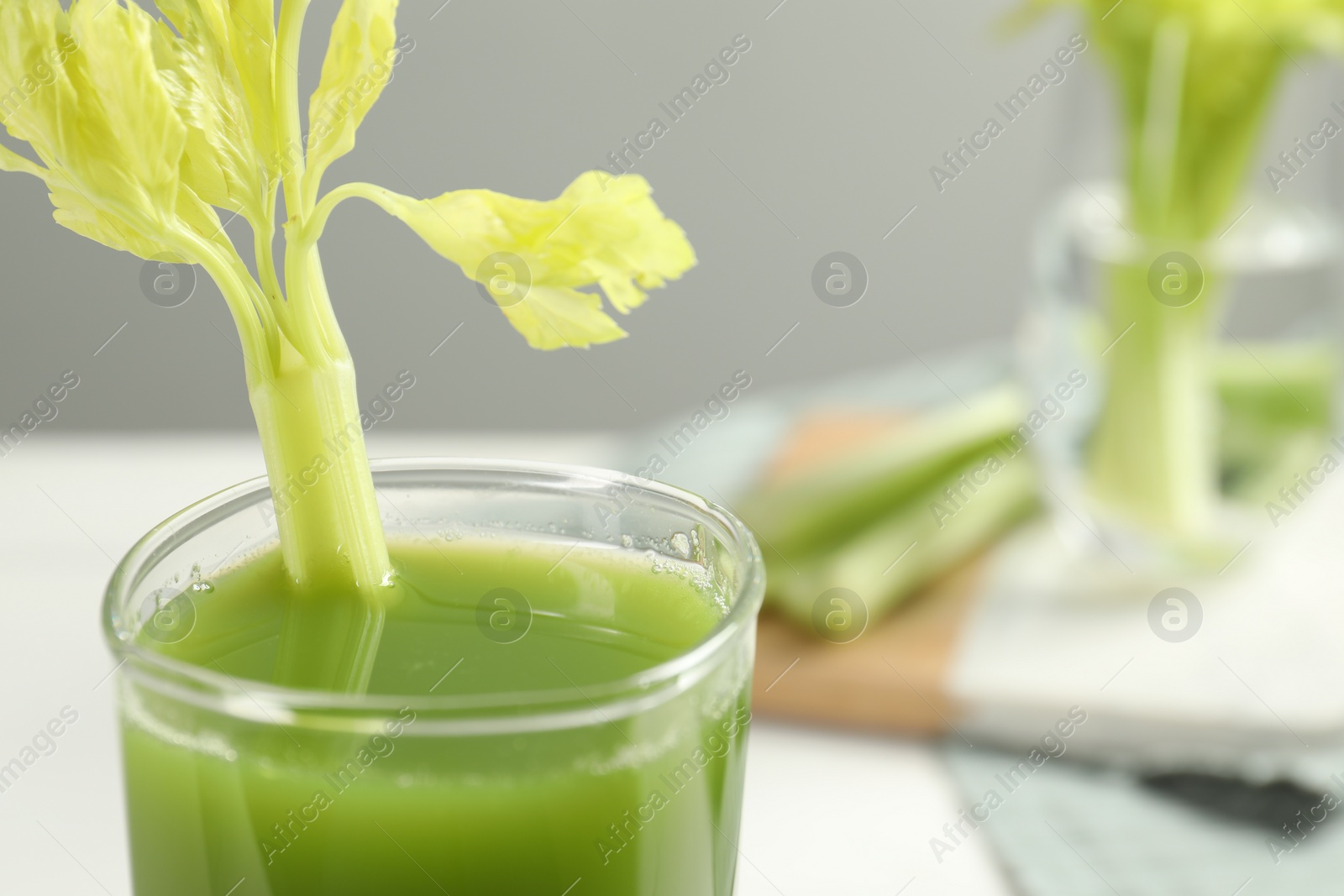 Photo of Glass of fresh celery juice against blurred background, closeup. Space for text