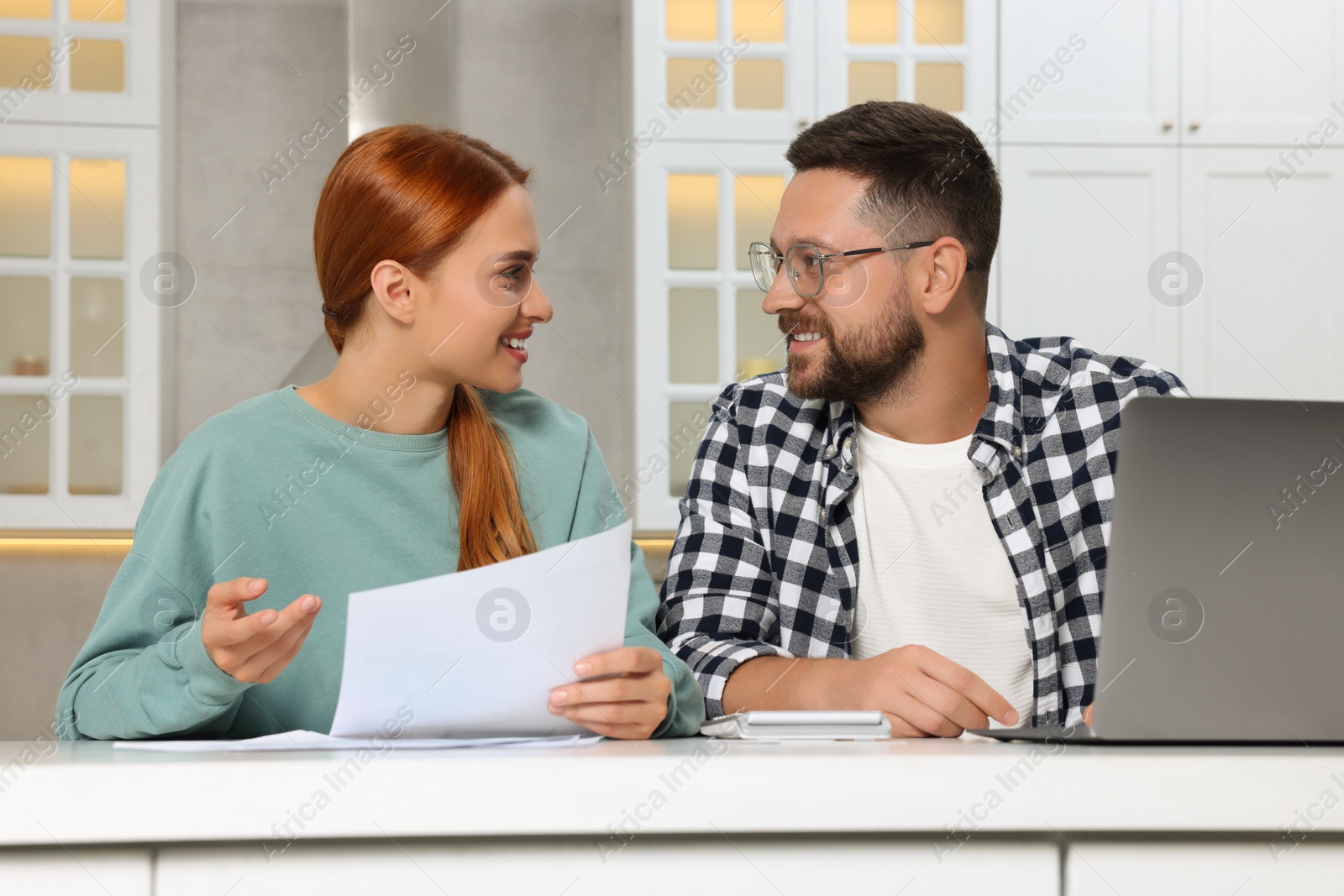 Photo of Couple doing taxes at table in kitchen