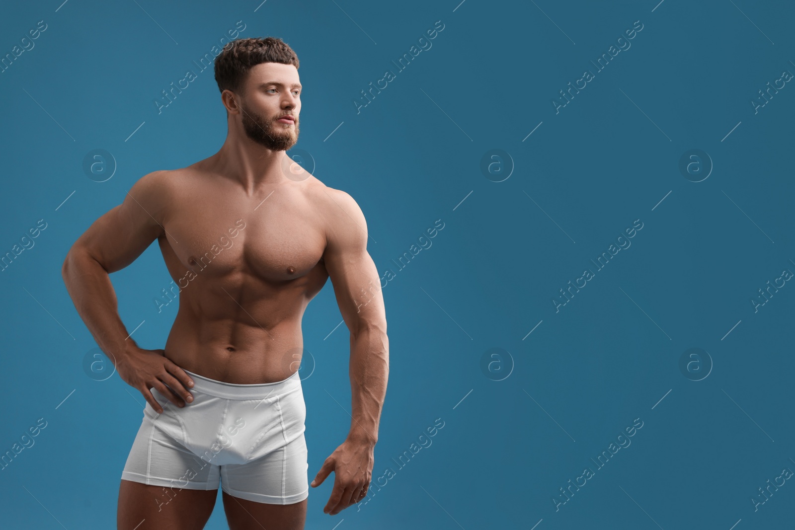 Photo of Handsome muscular man on light blue background, space for text. Sexy body