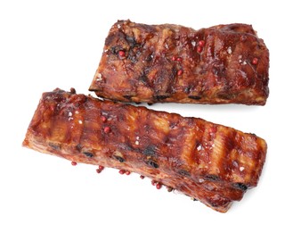 Photo of Tasty roasted pork ribs and peppercorns isolated on white, top view