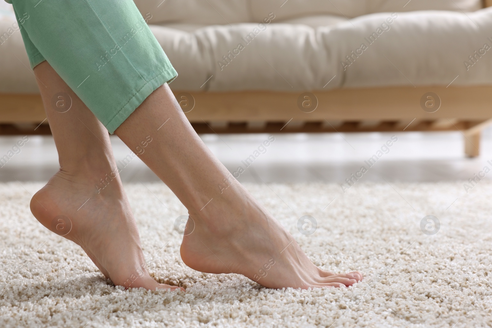 Photo of Woman on soft light brown carpet at home, closeup. Space for text