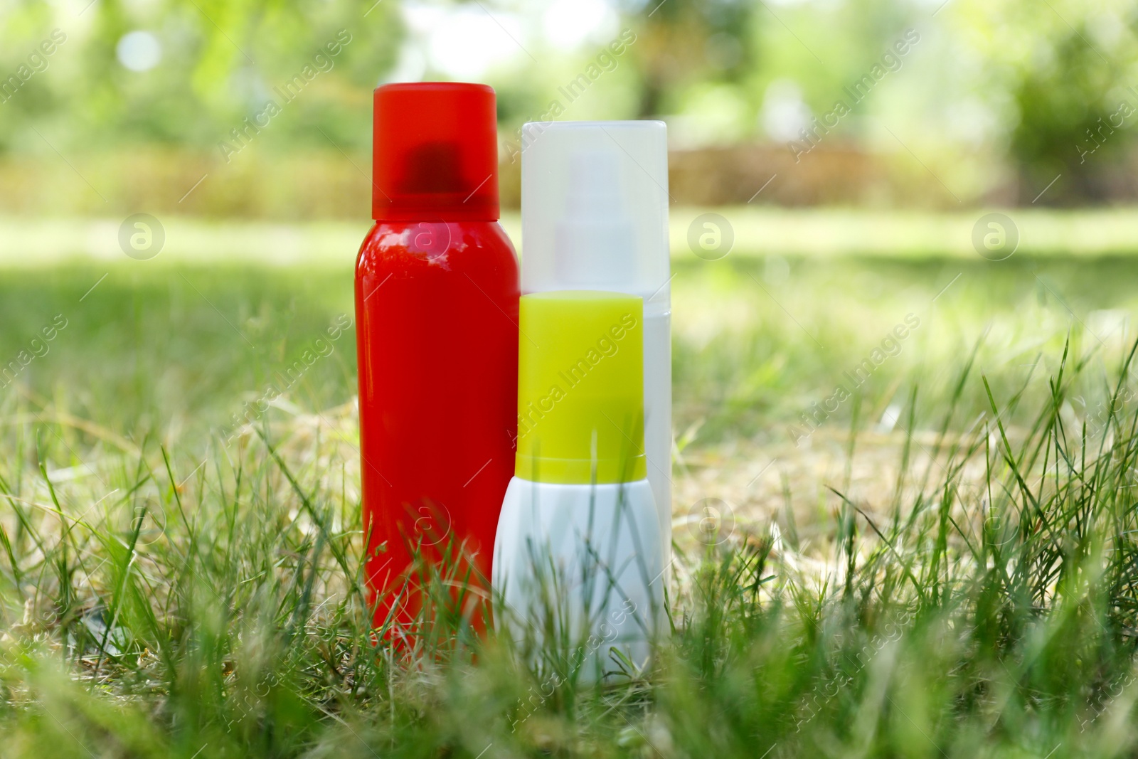 Photo of Bottles of insect repellent on green grass