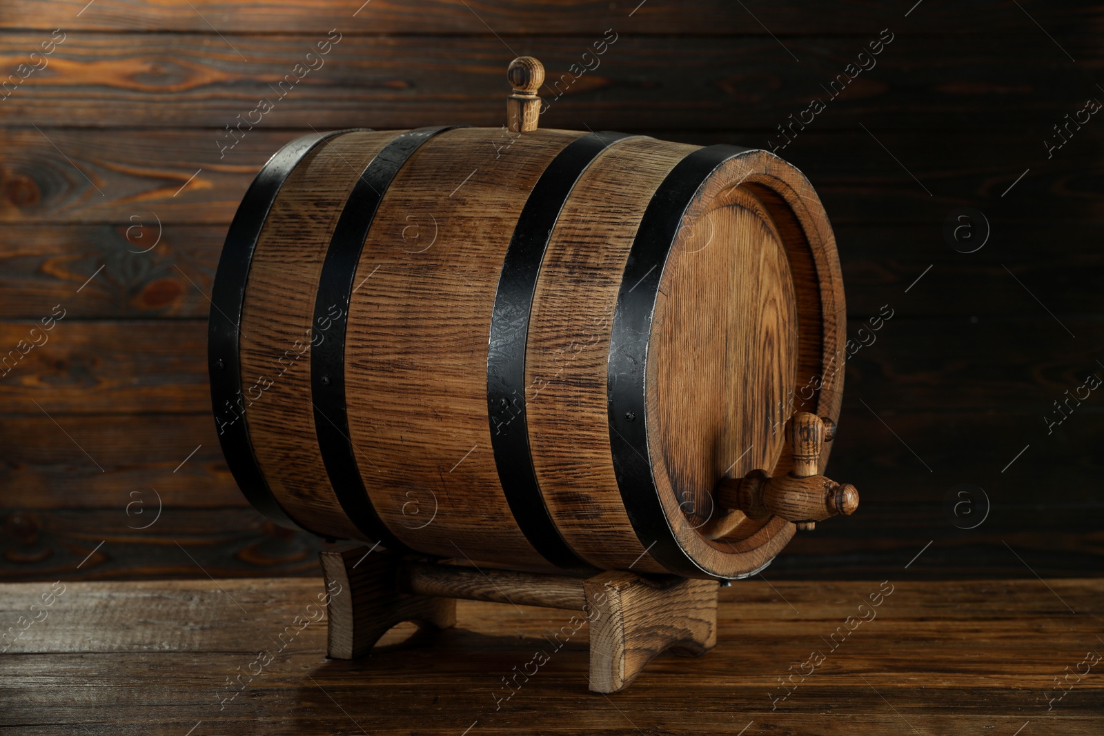 Photo of One wooden barrel with tap on table near wall, closeup