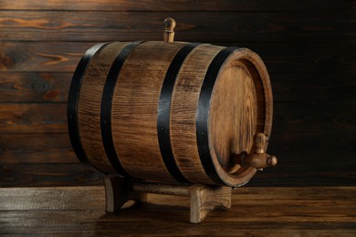 Photo of One wooden barrel with tap on table near wall, closeup