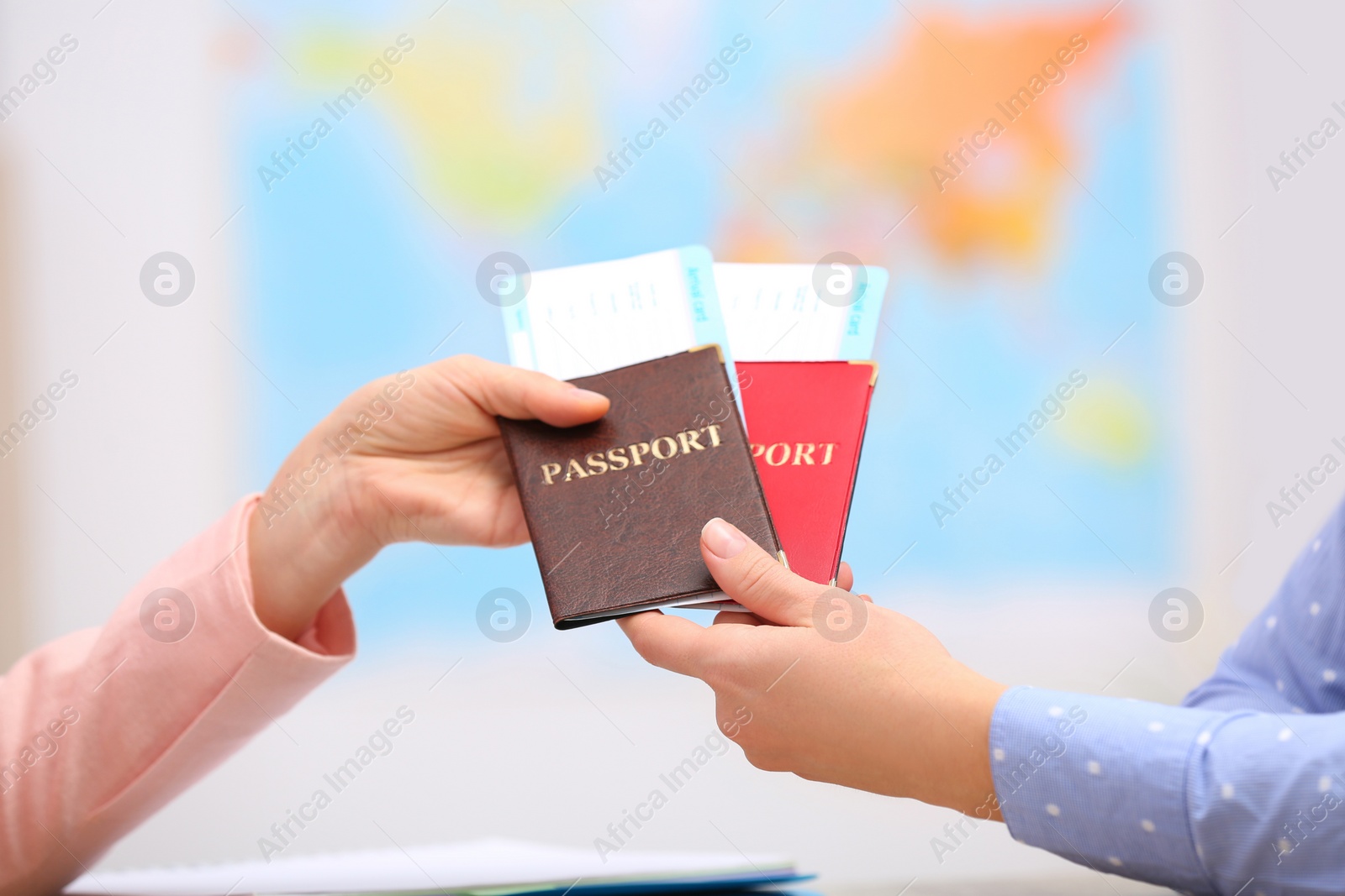 Photo of Female manager giving passports with tickets to client in travel agency, closeup