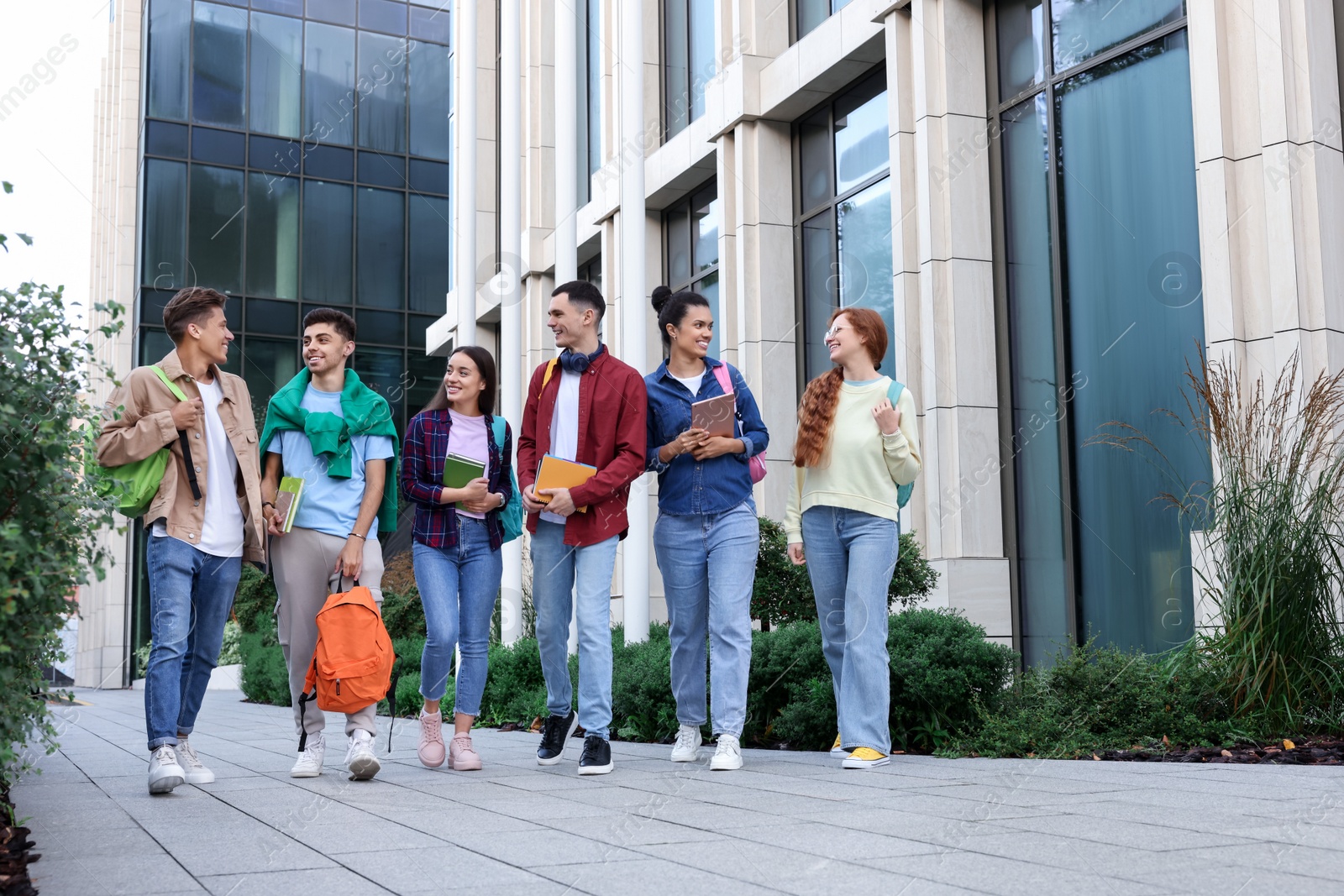 Photo of Group of happy students walking together outdoors