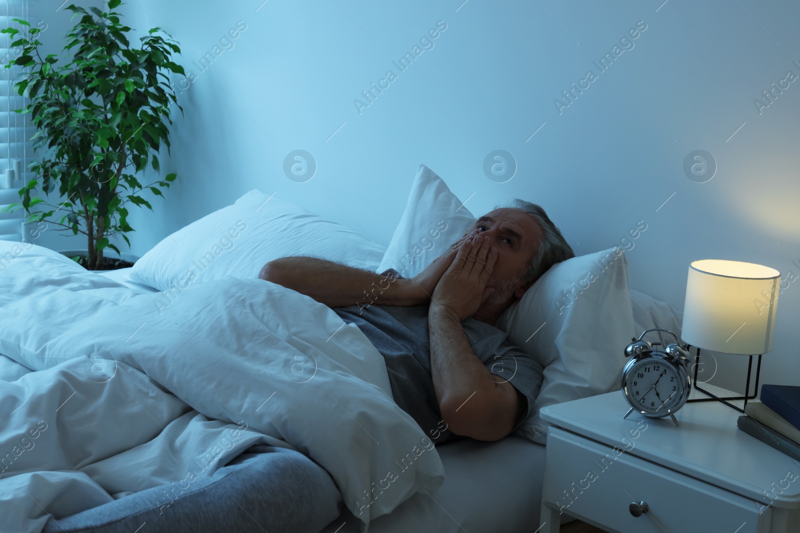 Photo of Sleepy senior man in bed at home