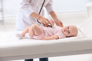 Photo of Children's doctor examining baby with stethoscope in hospital