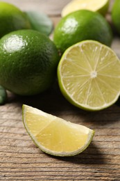 Photo of Fresh ripe limes on wooden table, closeup