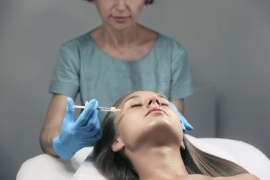 Photo of Beautiful woman getting facial injection in salon
