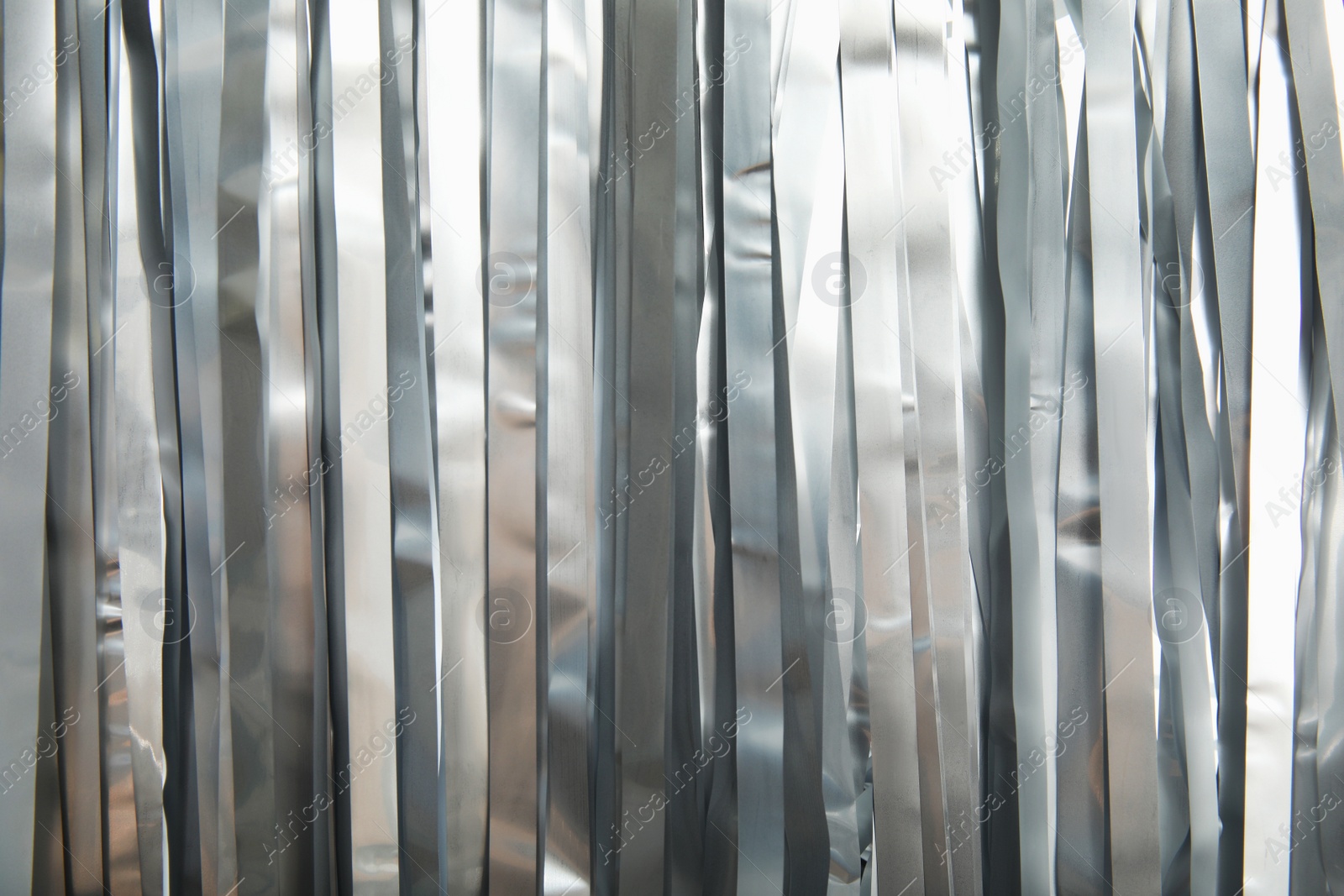 Photo of Shiny silver tinsel as background, closeup. Christmas decoration