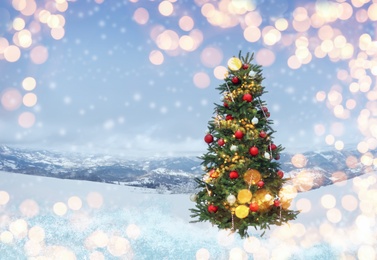 Image of Beautiful decorated Christmas tree outdoors, space for text. Bokeh effect