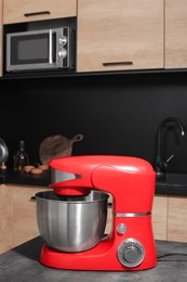 Modern stand mixer on grey table in kitchen