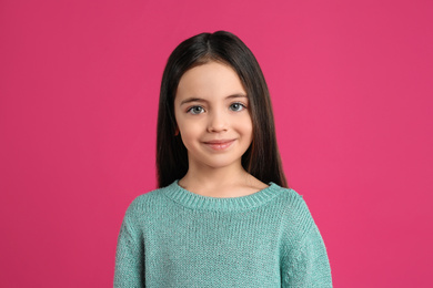 Photo of Portrait of cute little girl on pink background