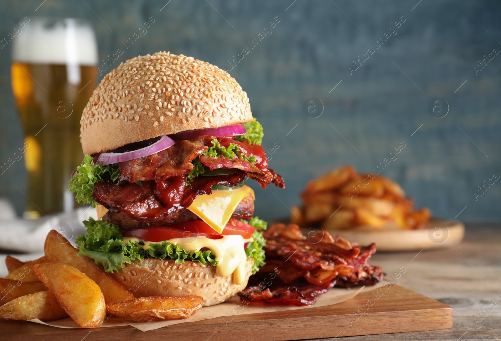 Photo of Composition with juicy bacon burger on wooden table. Space for text