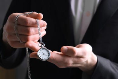 Man holding chain with elegant pocket watch, closeup