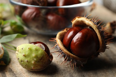 Horse chestnuts on wooden table, closeup view