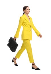 Photo of Beautiful businesswoman in yellow suit with briefcase walking on white background