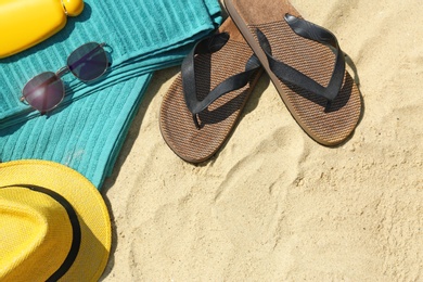 Set of beach accessories on sand, above view. Space for text