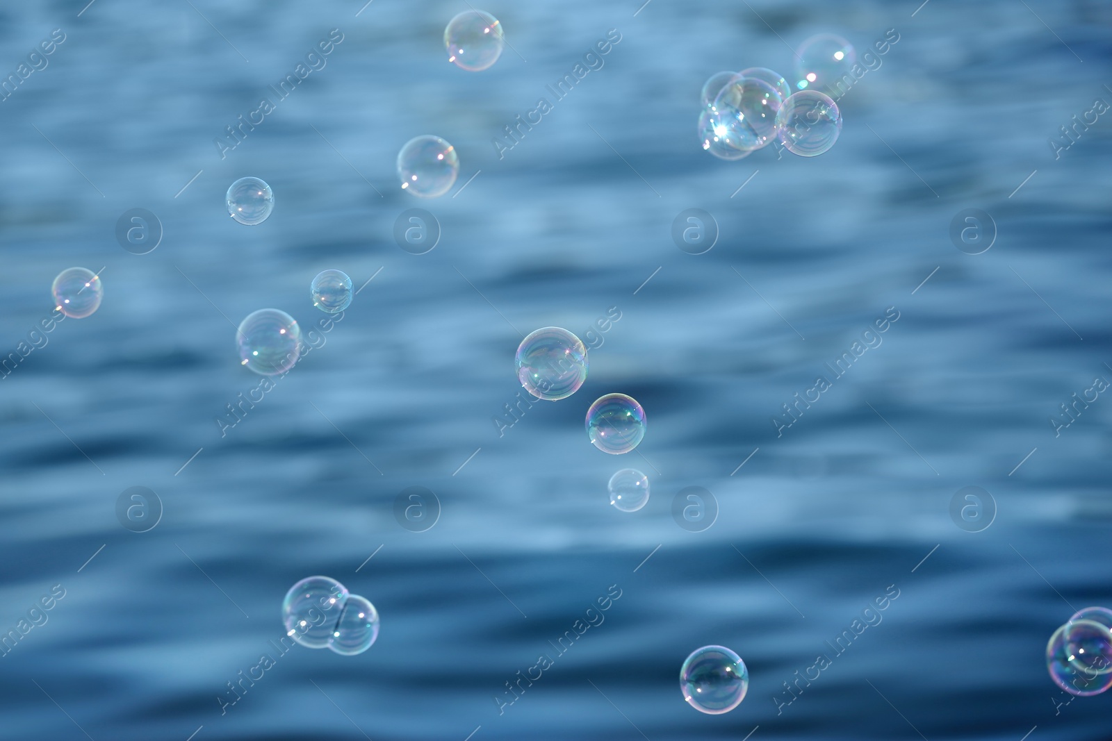 Photo of Beautiful translucent soap bubbles outdoors on sunny day