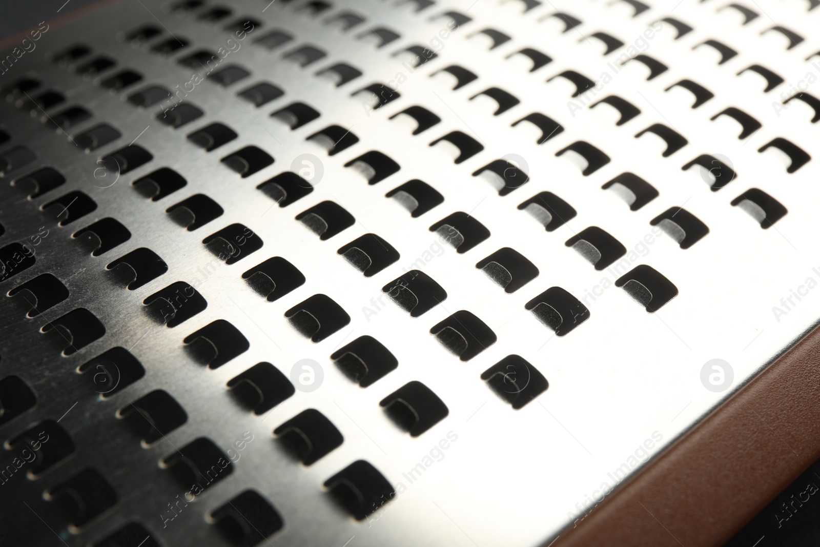 Photo of Modern metal grater as background, closeup view