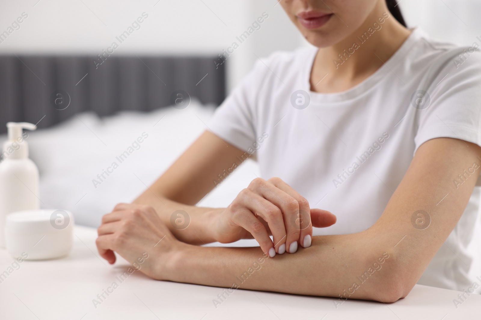 Photo of Woman with dry skin checking her arm indoors, closeup