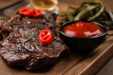 Delicious fried steak and sauce on wooden table, closeup