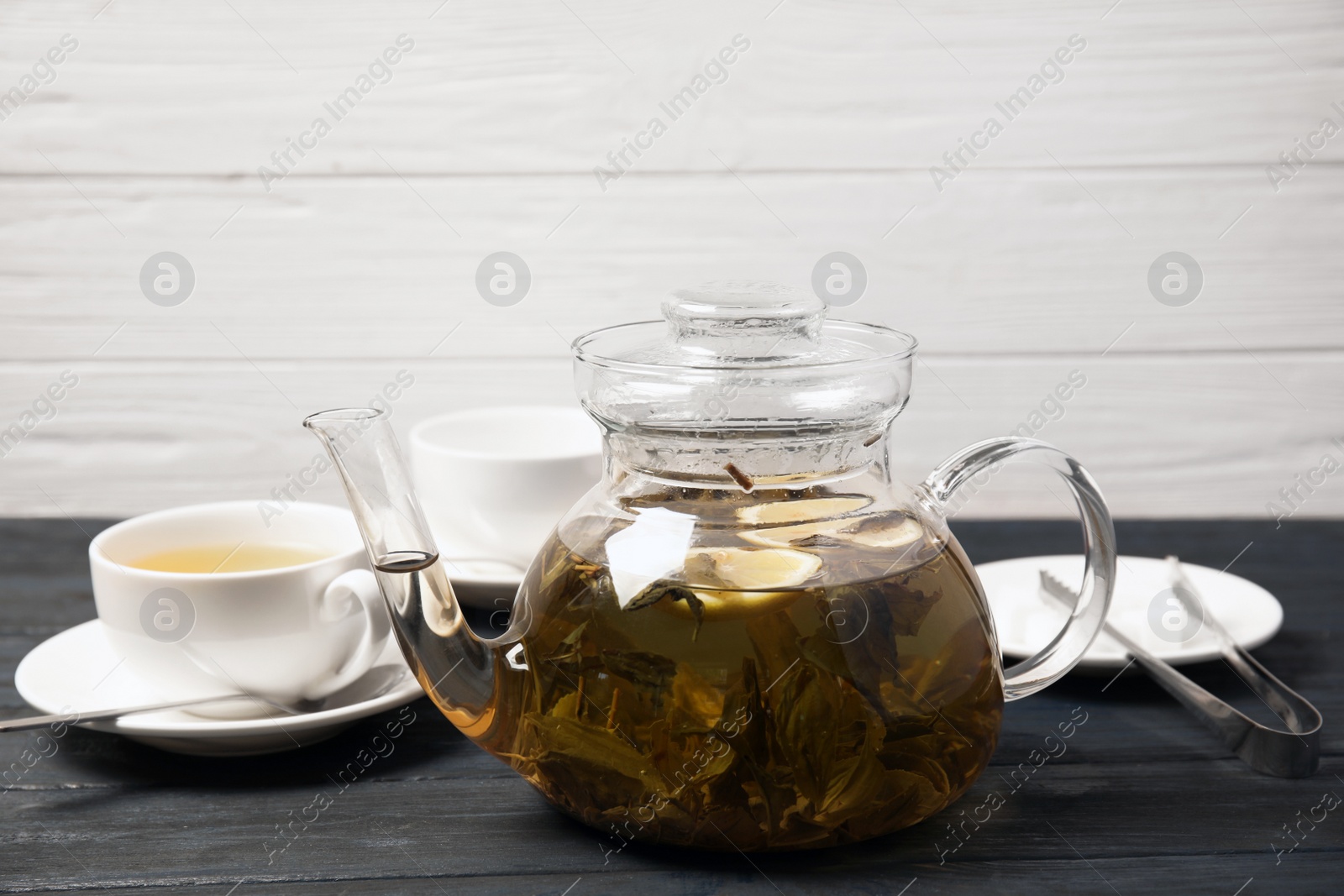 Photo of Teapot with hot aromatic tea on table