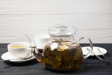 Teapot with hot aromatic tea on table