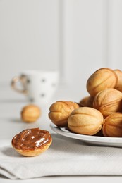 Photo of Homemade walnut shaped cookies with boiled condensed milk on table, space for text