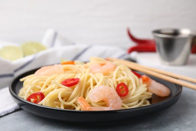 Photo of Tasty spaghetti with shrimps and chili pepper on grey table, closeup